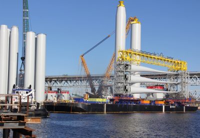 The tubine blades and tower sections are being shipped by barge to the construction site.